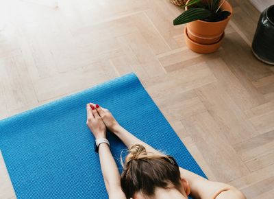 A yoga mat rolled out in a peaceful, sunlit room.
